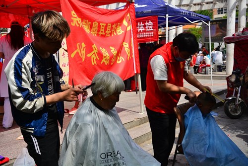 图为理发店人员为群众义务理发 图为理发店人员为群众义务理发