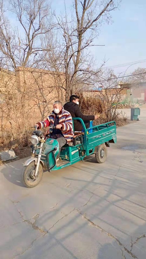 图为徐泽清和村干部一起进行村内道路消毒 图为徐泽清和村干部一起进行村内道路消毒