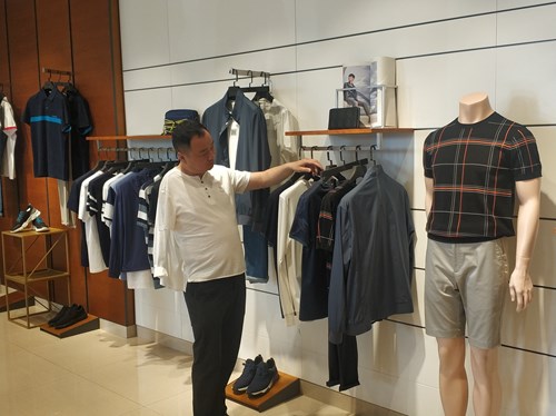 图为宋建伟在店内整理服装 图为宋建伟在店内整理服装